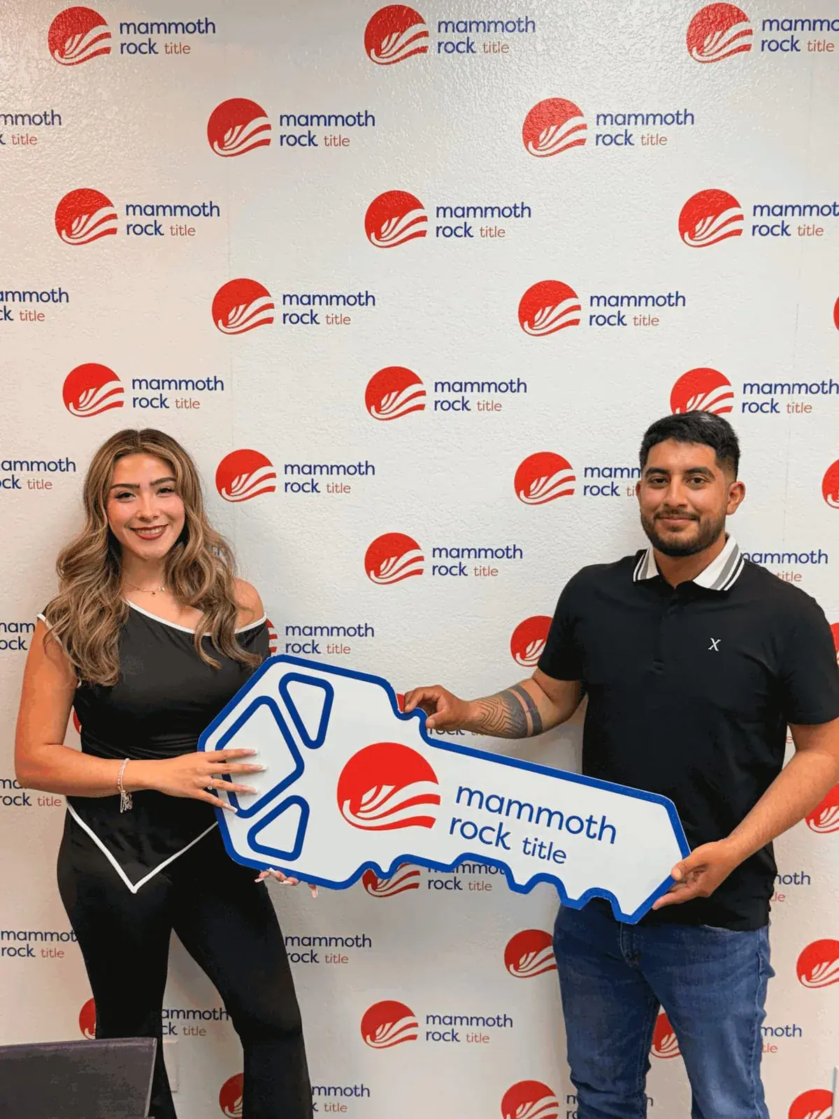 Ximena Martinez and a client holding a giant key at closing